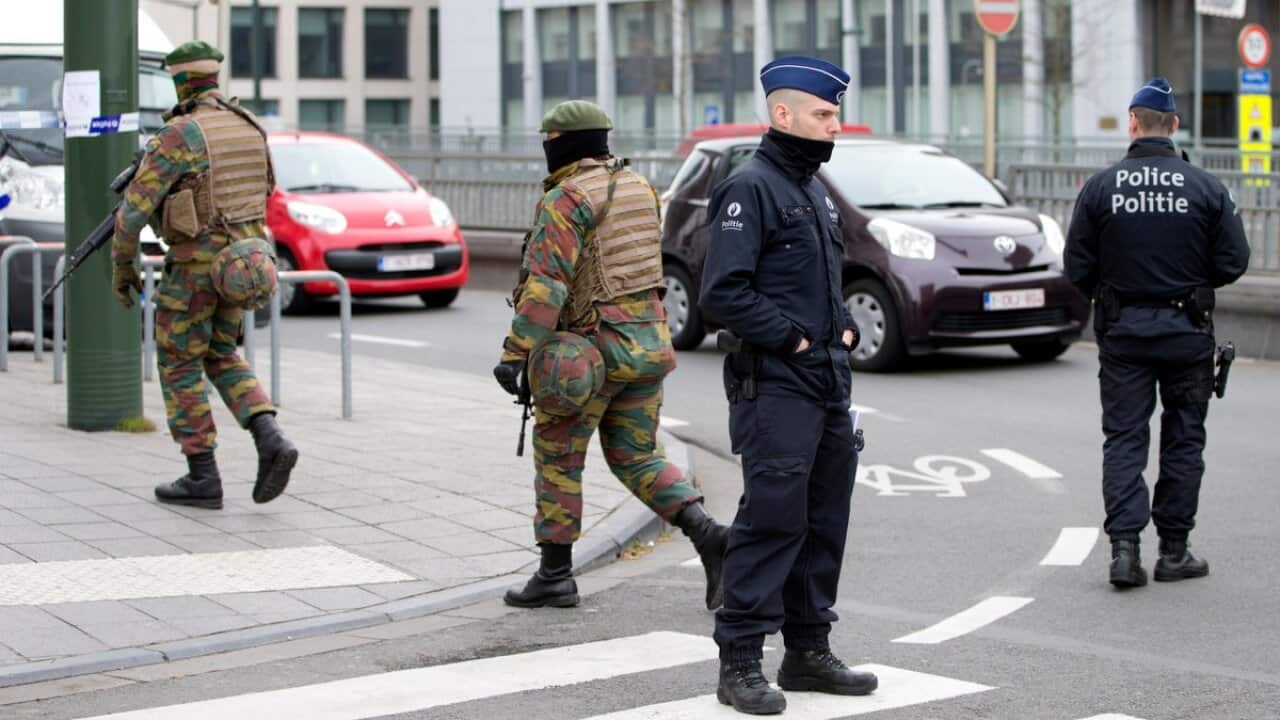 Police and Belgian Army soldiers patrol outside the federal court building in Brussels on Thursday, April 14, 2016. (AAP)