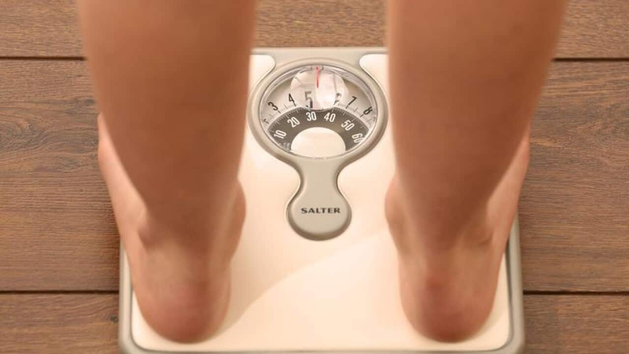 A stock image of feet stand on a scale.
