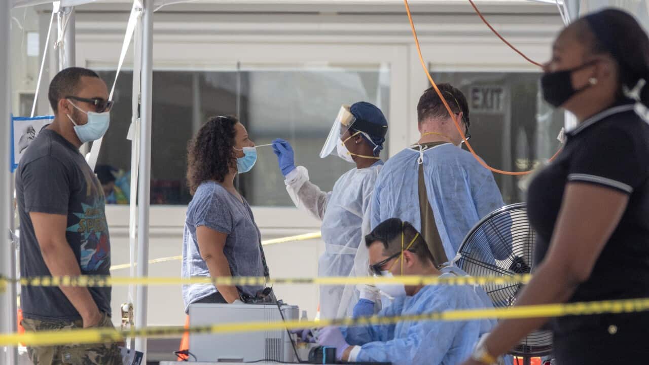 A woman receives the COVID-19 coronavirus walk-up testing service by the Florida Army National Guard