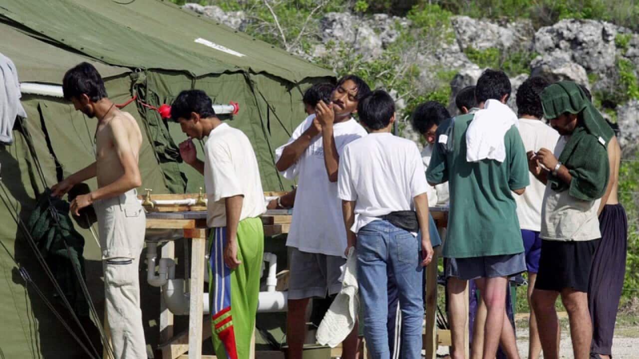 Men prepare for the day at a refugee camp on the Island of Nauru
