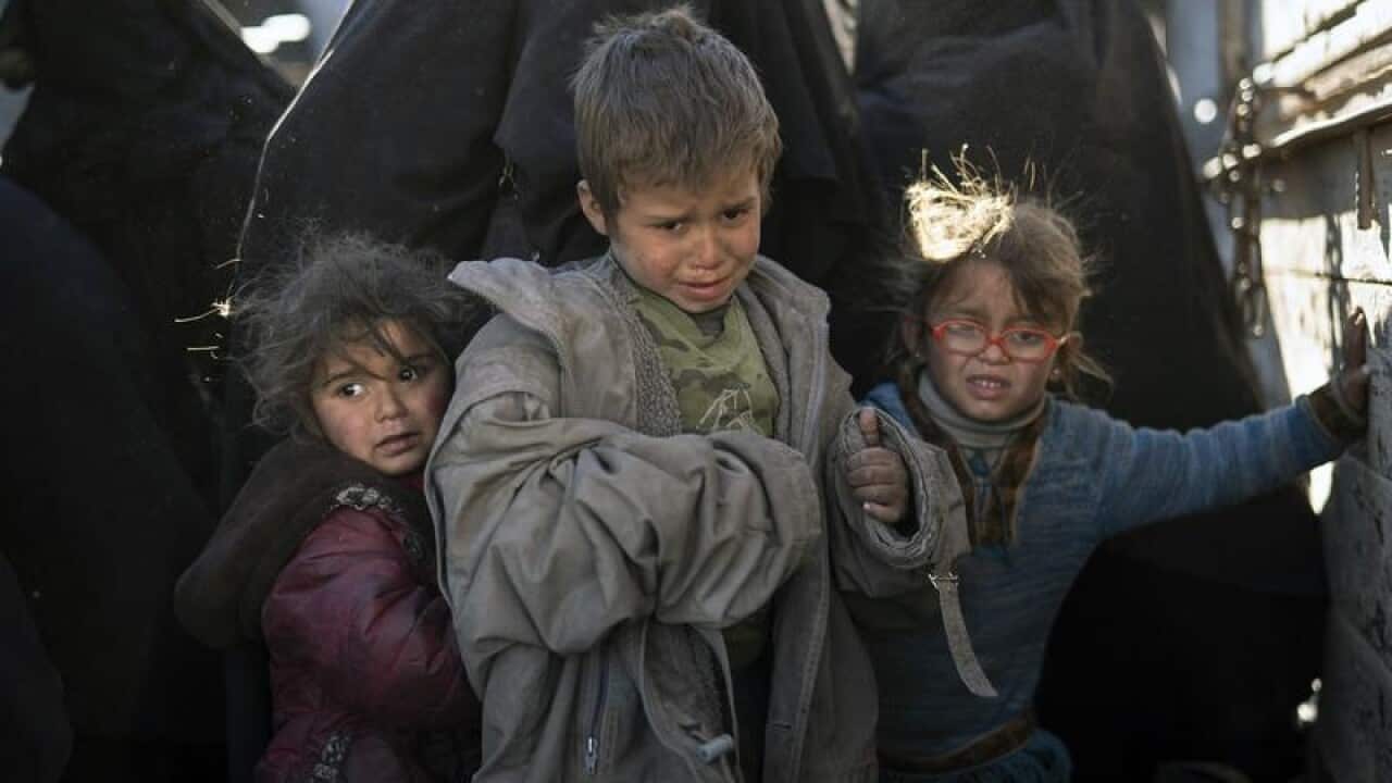 Children get off a truck as they arrive at an SDF checkpoint