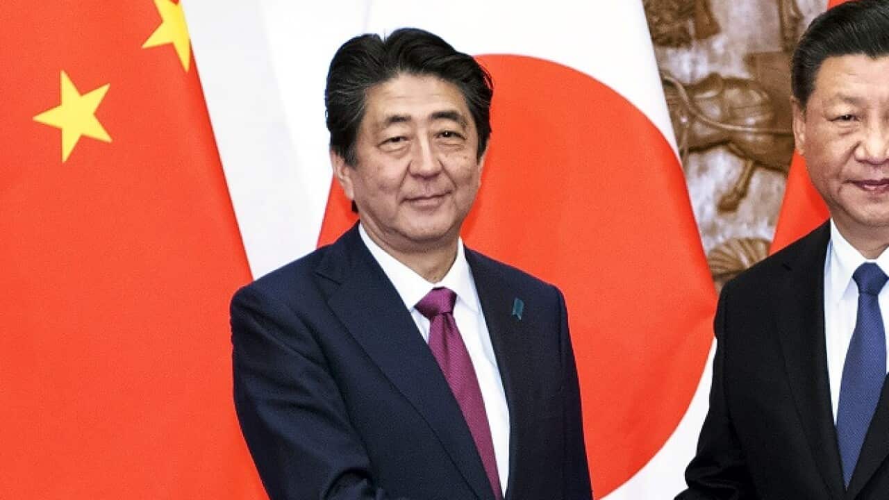 Japanese PM Shinzo Abe, left, shakes hands with Chinese President Xi Jinping during a rare visit. 