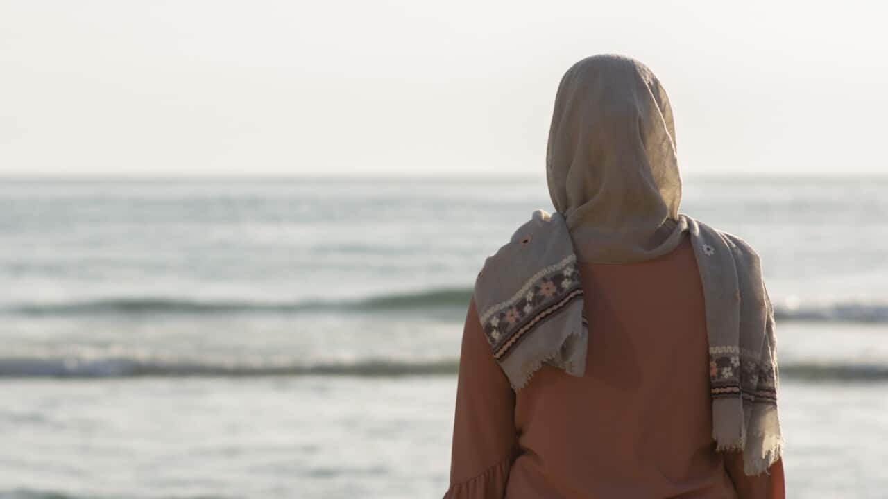 Rear view of Muslim woman wearing Hijab standing on the beach