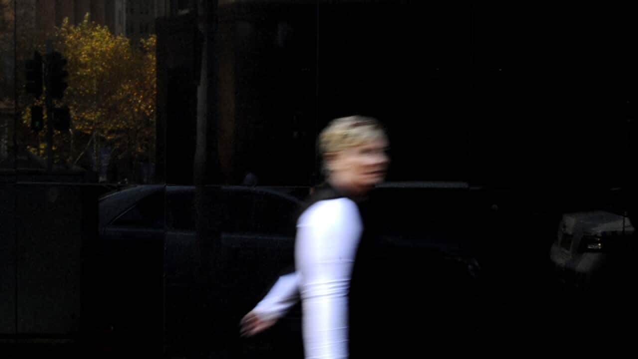 A man walks past the RBA building in Sydney