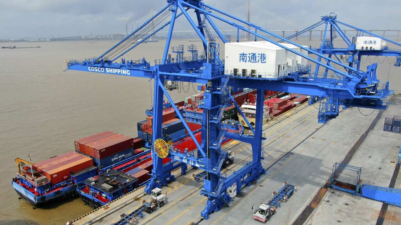 Shipping containers are loaded onto a cargo ship at a port in Nantong in eastern China's Jiangsu province.