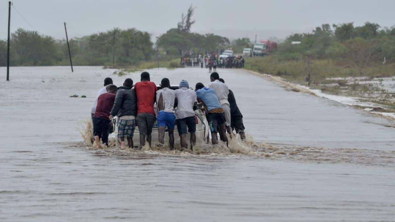 Residents push a car through the floods in Mazive, southern Mozambique.