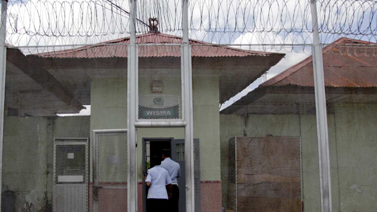 Prison guards stand outside a gate of Kerobokan Prison in Bali