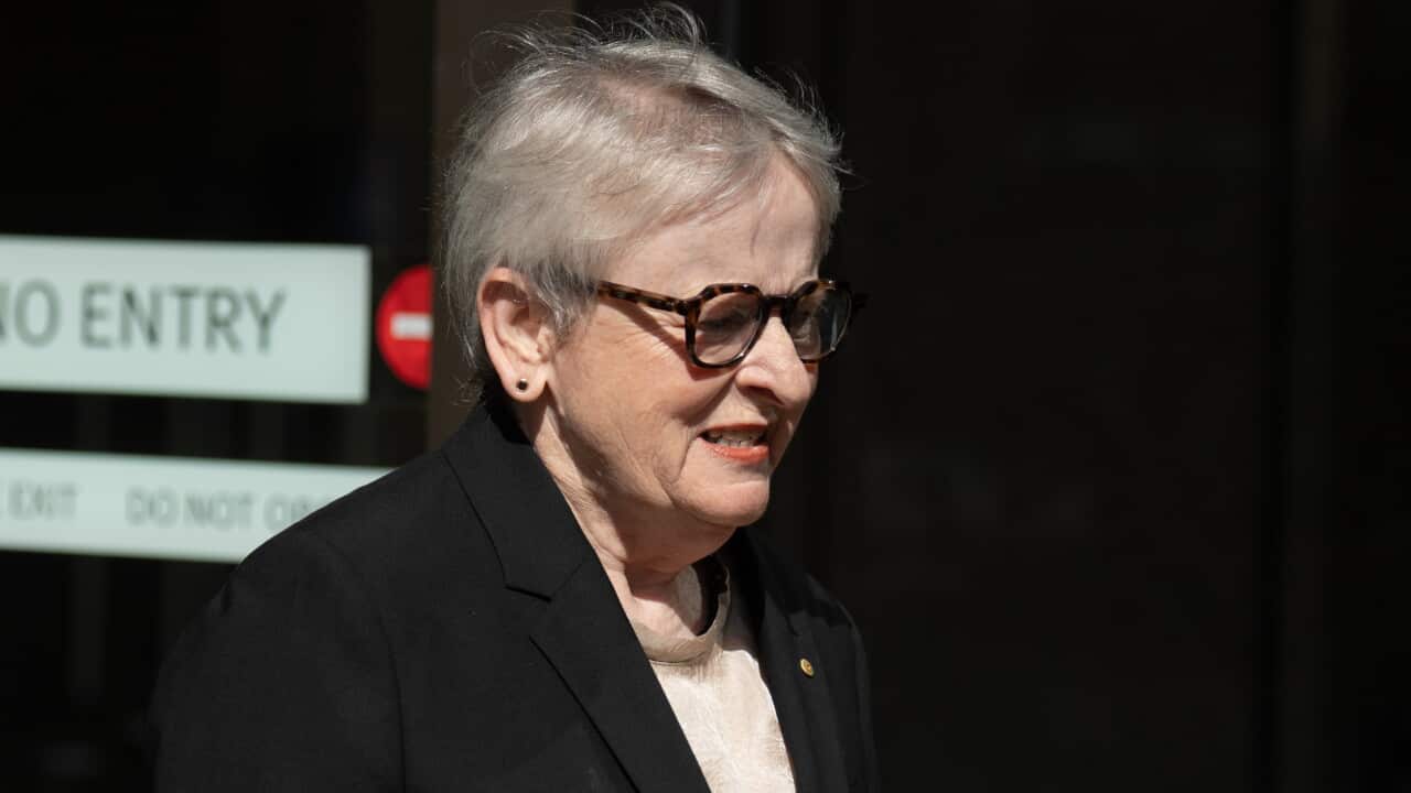 A woman in a black suit outside