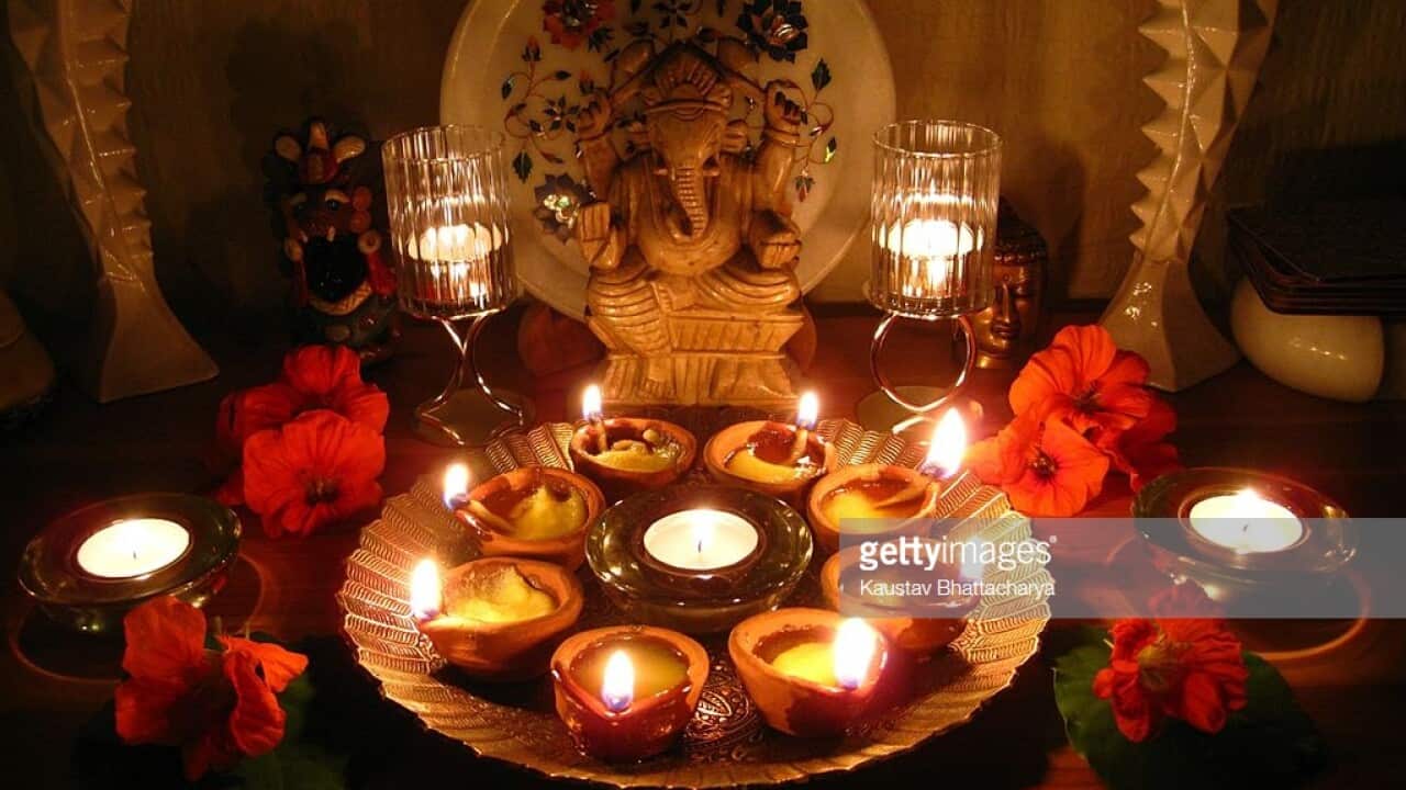 Ganesha, pradeeps and candles flanked by Gaudi inspired candle holders in the photo celebrating the Hindu Festival of Lights.