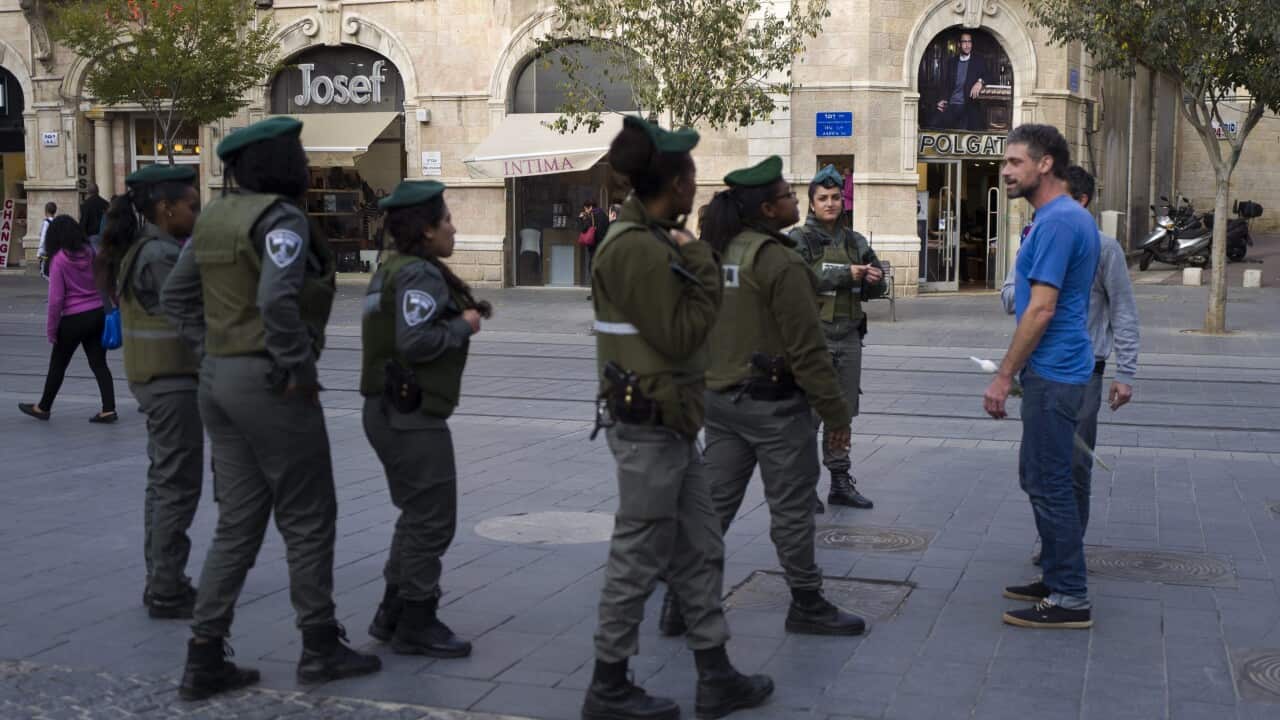 Israeli Border Policewomen patrol in central west Jerusalem as they stop two young men to ask their identities, 22 November 2015. (EPA/JIM HOLLANDER)