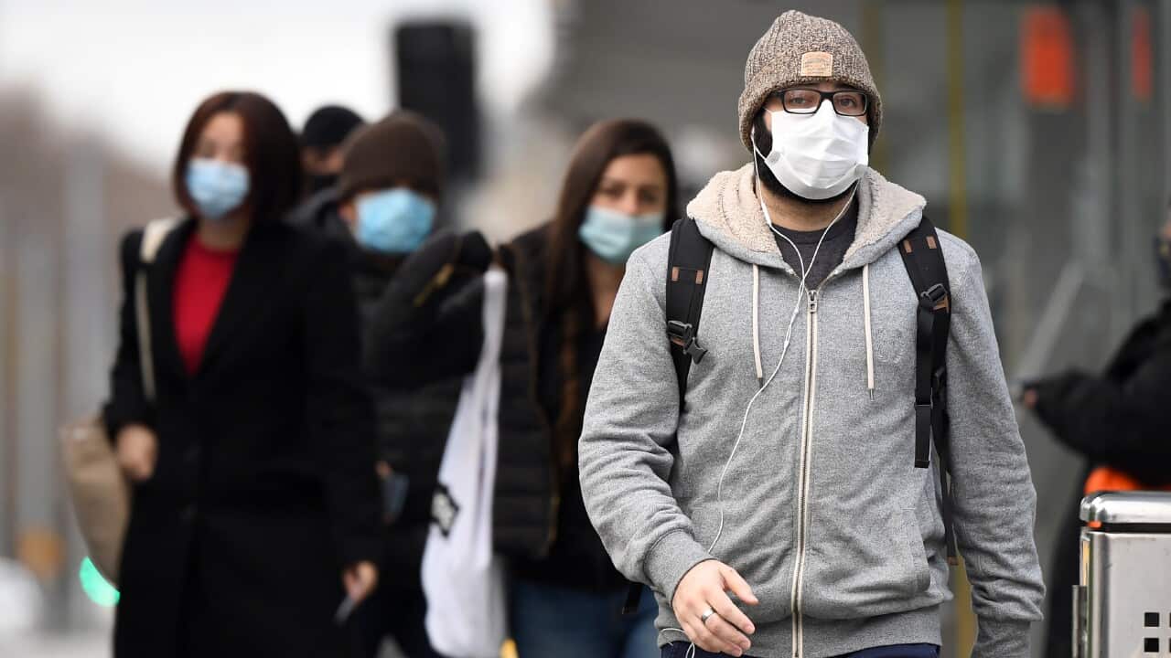 Commuters walk past Melbourne's Flinders Street Station on 23 July, 2020 on the first day of the mandatory wearing of face masks in public areas.