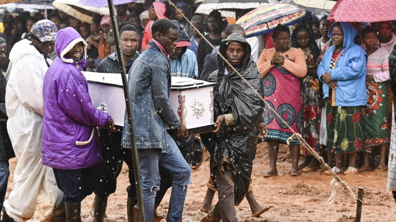 People attend the burial ceremony of some of the people who lost their lives following heavy rains caused by Cyclone Freddy in Blantyre, southern Malawi.