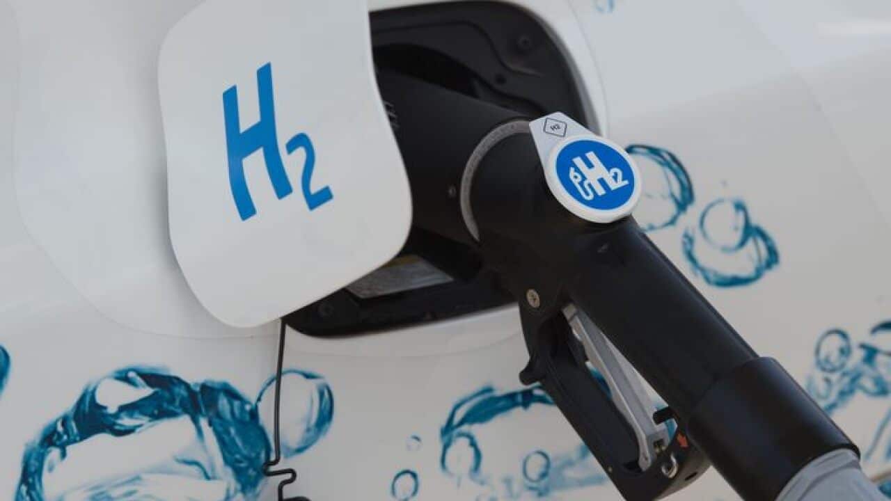 A nozzle from a hydrogen filling station is seen inserted in the filler neck of a hydrogen car