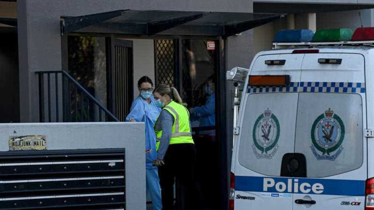 SW Health workers outside an apartment block on Campbell Street in Liverpool, after fourteen cases of COVID-19 were confirmed in the building, August 7, 2021.