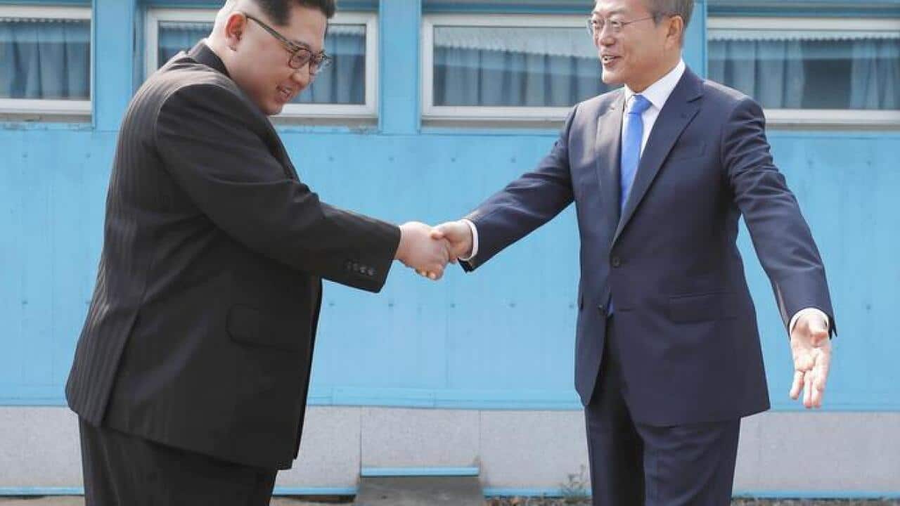 South Korean President Moon Jae In (R) and North Korean leader Kim Jong Un shake hands across the border between their countries at Panmunjeom in the Demilitarized Zone on April 27, 2018. (Korea Summit Press Pool)(Kyodo)==Kyodo