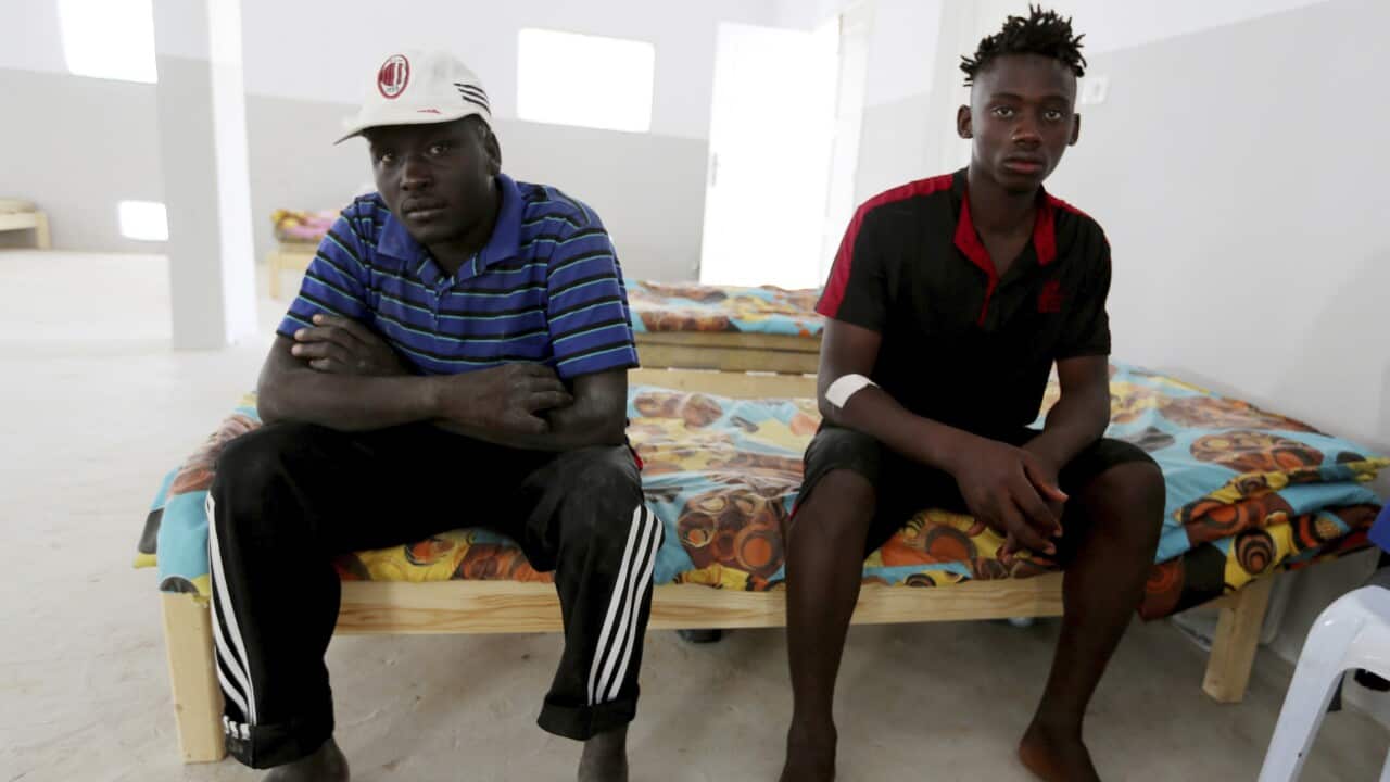 An unidentified Malian survivor, right, of a shipwreck sits in the Red Crescent center of Zarzis, southern Tunisia.