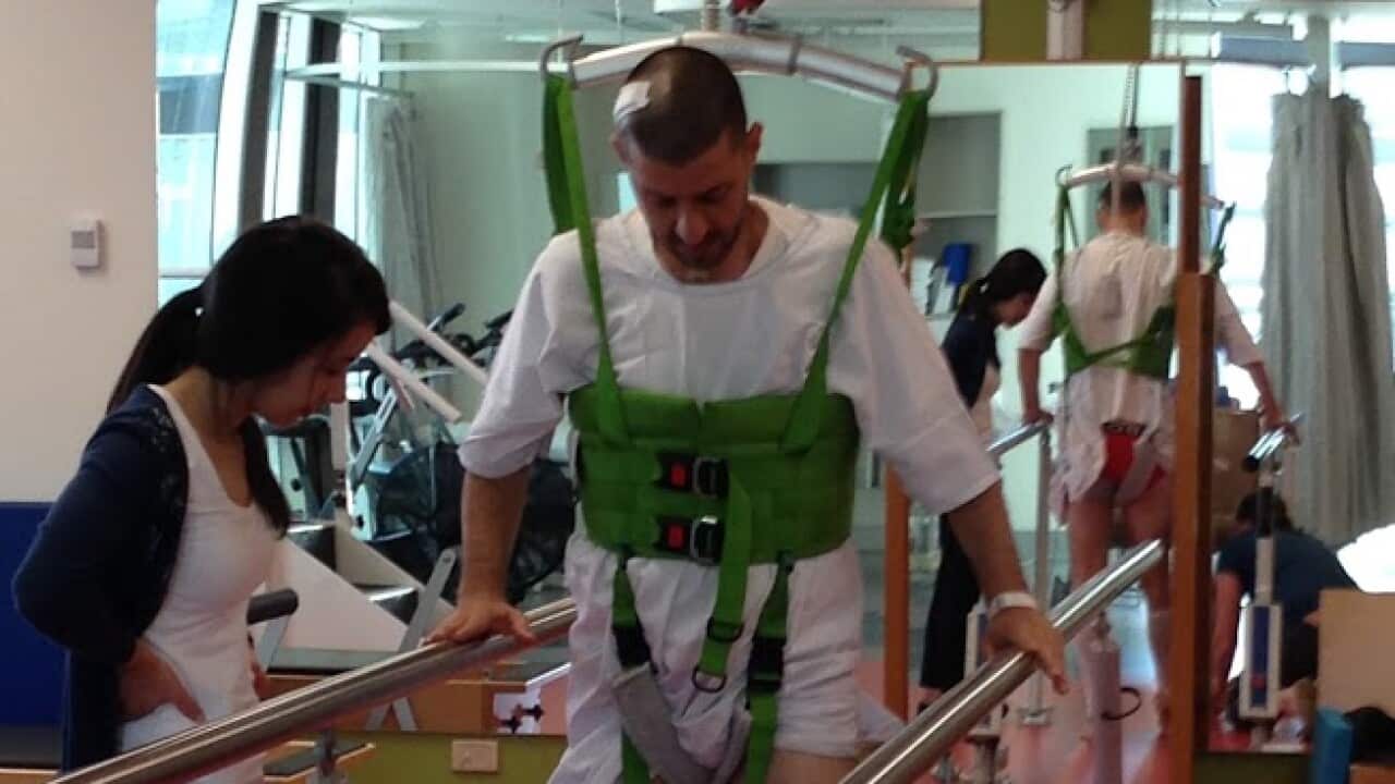 Bill Gasiamis learns to walk with supporting rails.