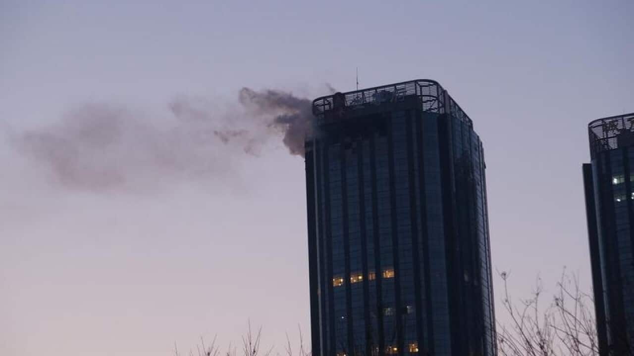 Smoke rises from the upper floors of Tianjin City Tower.