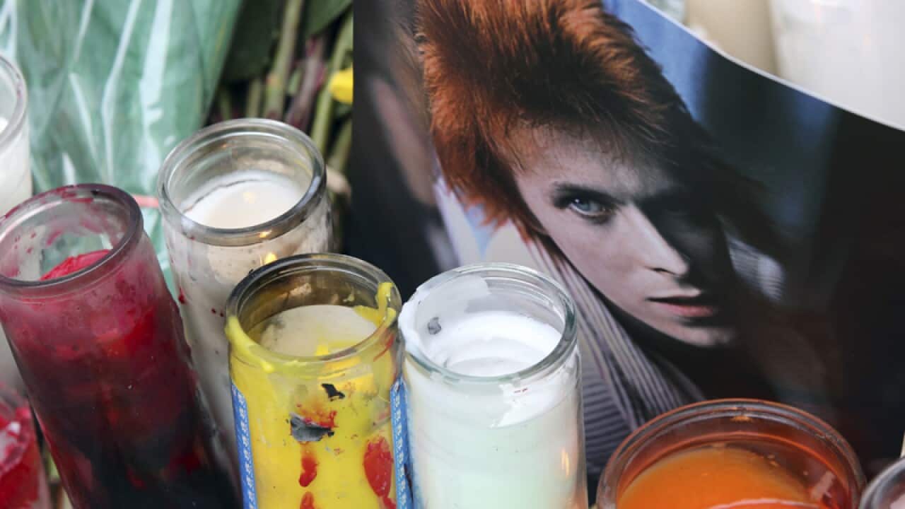 Candles and a photograph at a memorial for David Bowie