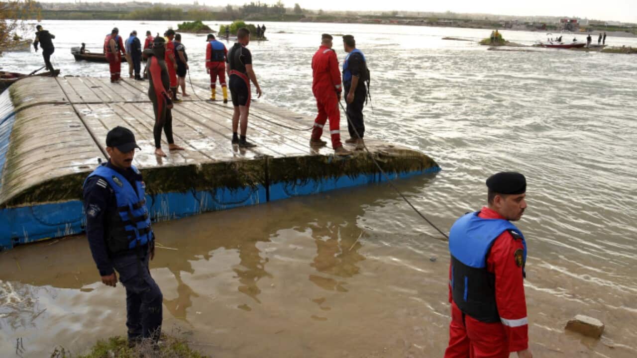 Members from Iraqi civil defense remove the sunken ferry in the Tigris river near Mosul