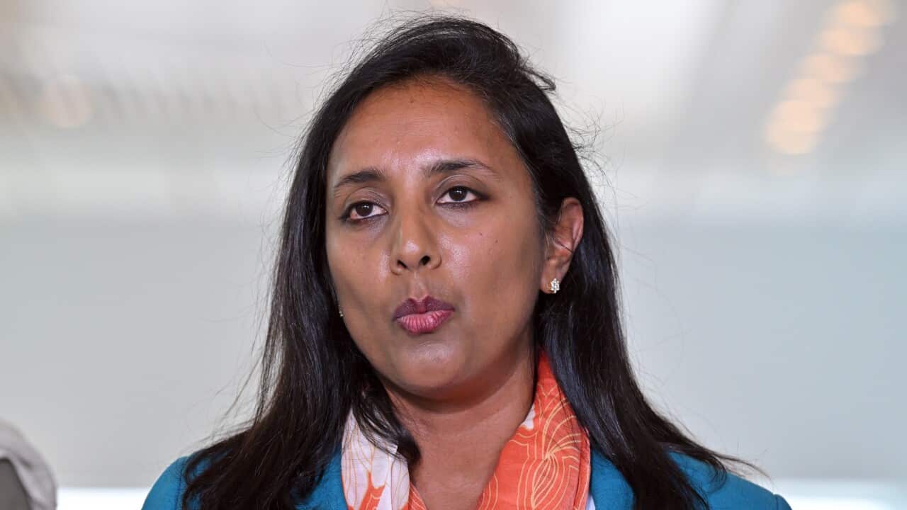 A woman in a blue blazer and orange scarf
