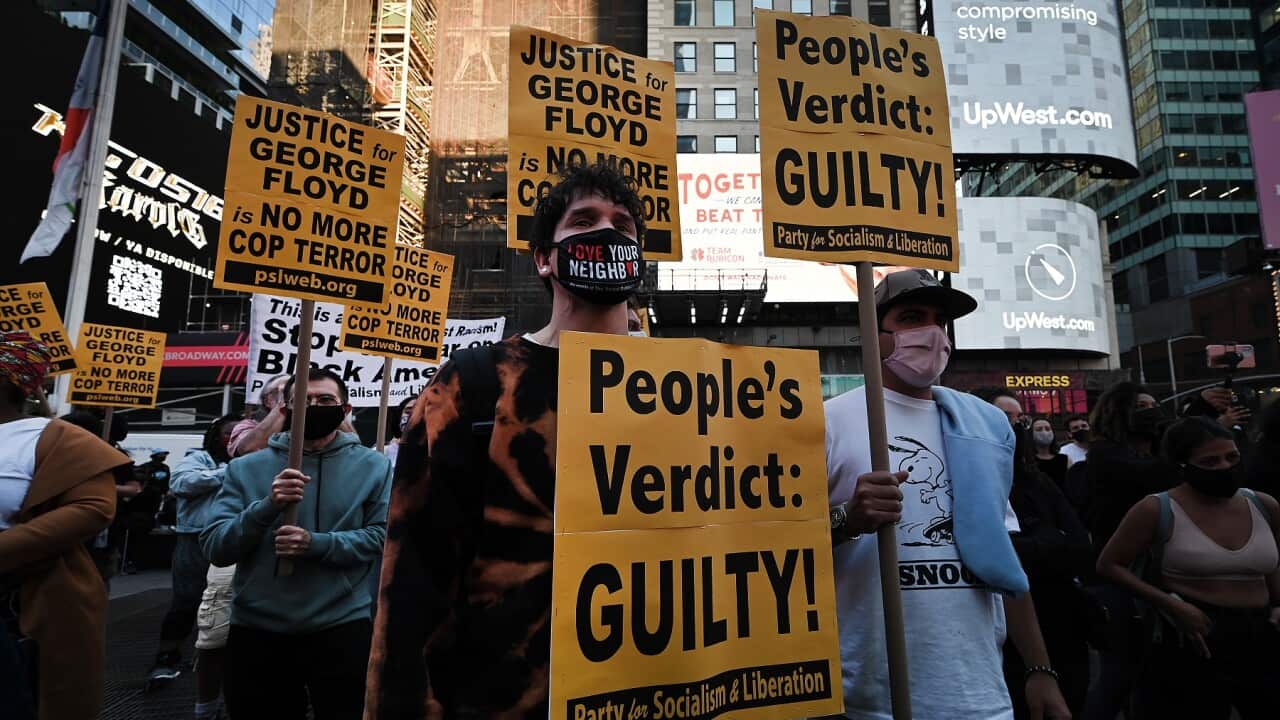 People hold signs up after the verdict in the trial of Derek Chauvin