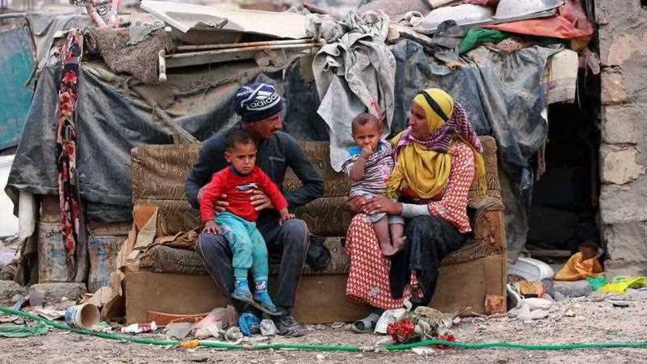 Hammadi Abdullah, 32, and his family sit outside their hut in an encampment outside Baghdad, Iraq.