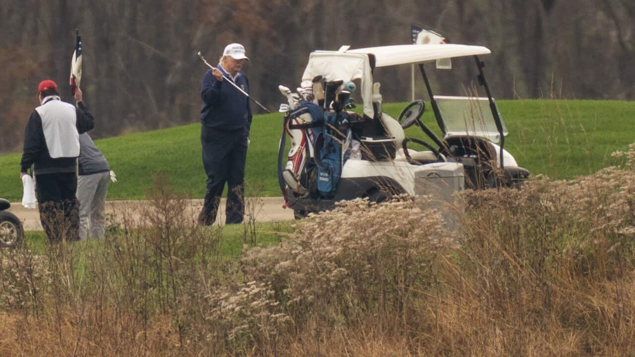 President Trump walks towards his golf cart as he plays golf at Trump National Golf Club in Virginia