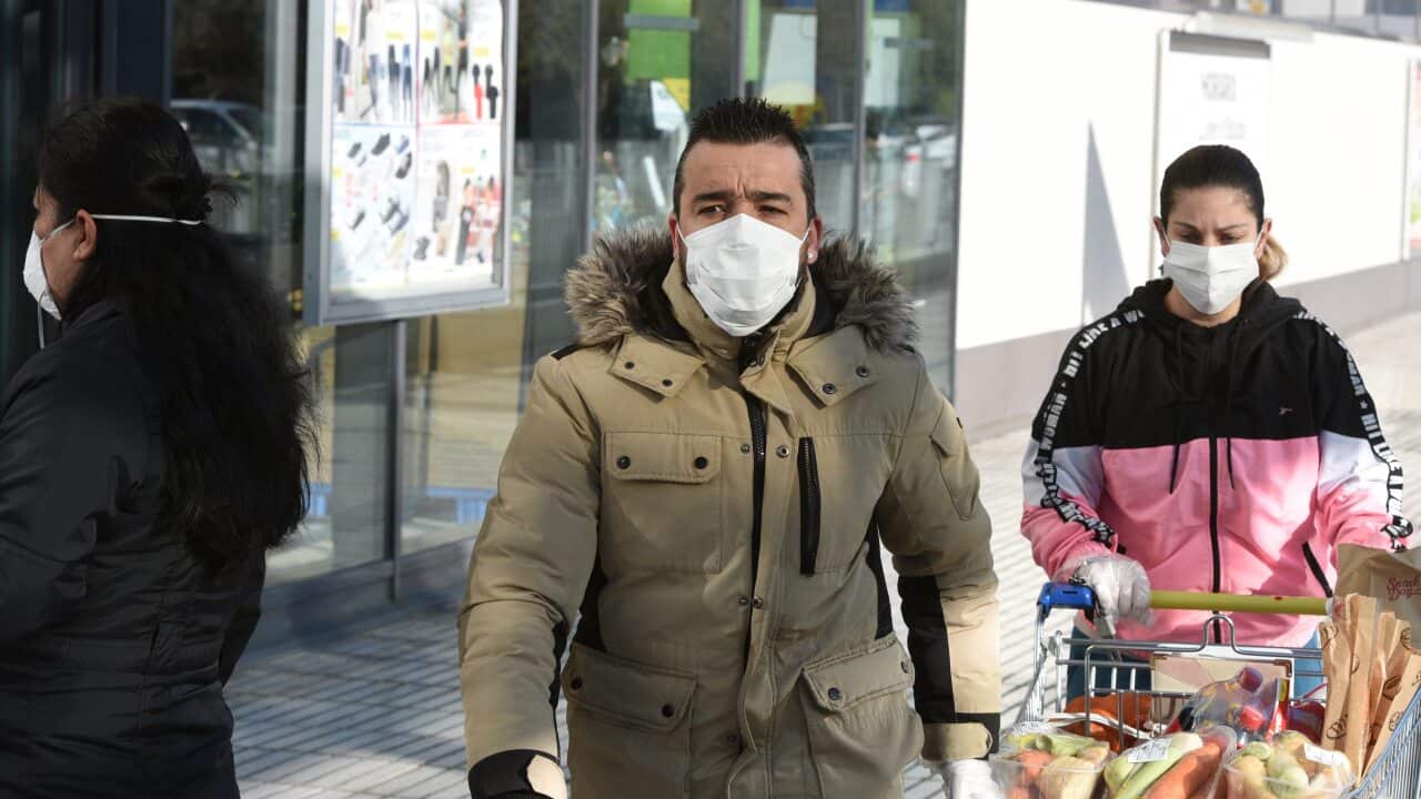 A couple wearing face masks as a precaution against the spread of Coronavirus at a supermarket in Madrid.