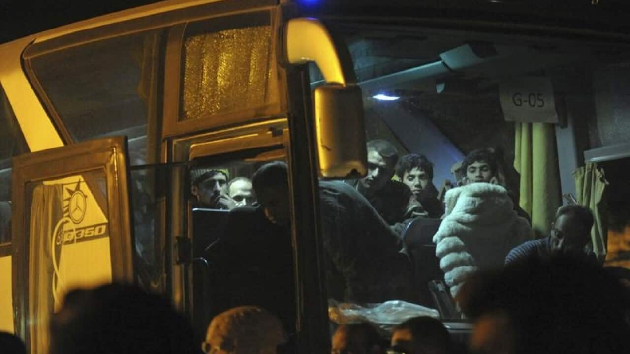 Rebels and their families get on a bus in eastern Ghouta