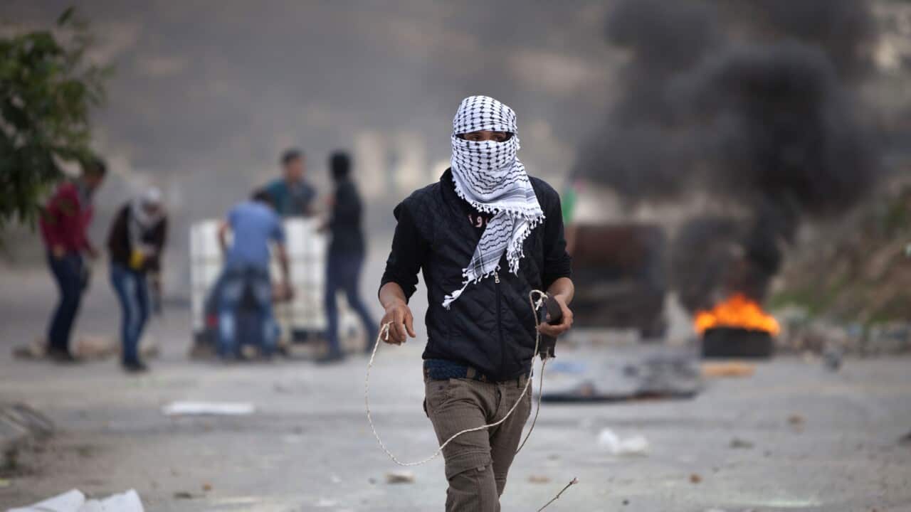 A Palestinian uses a slingshot during clashes with Israeli soldiers, outside the Ofer military prison, near the West Bank city of Ramallah (AP)