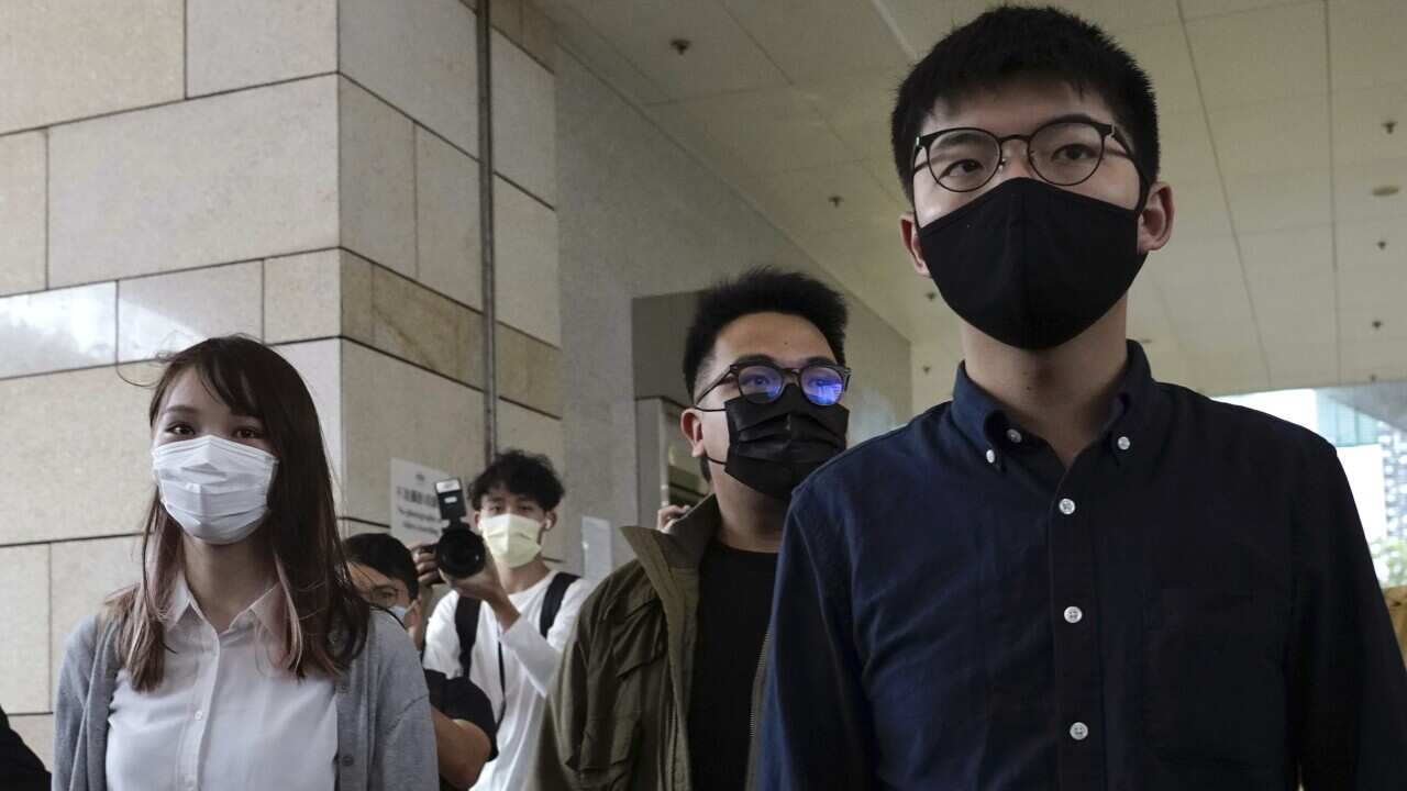 Hong Kong activists, from right, Joshua Wong, Ivan Lam and Agnes Chow arrive at a Hong Kong court.