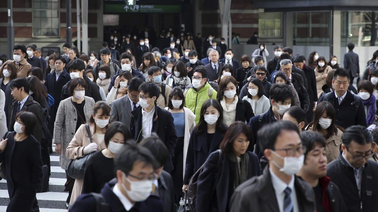 People wearing a mask commute at JR Tokyo Station in Tokyo, Japan.