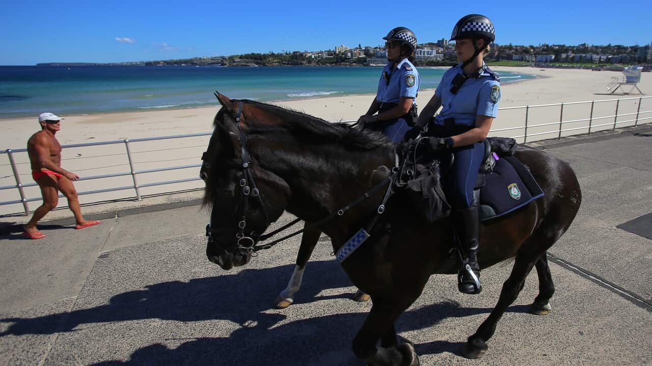 Police on horses enforce social distancing regulations at Bondi Beach.