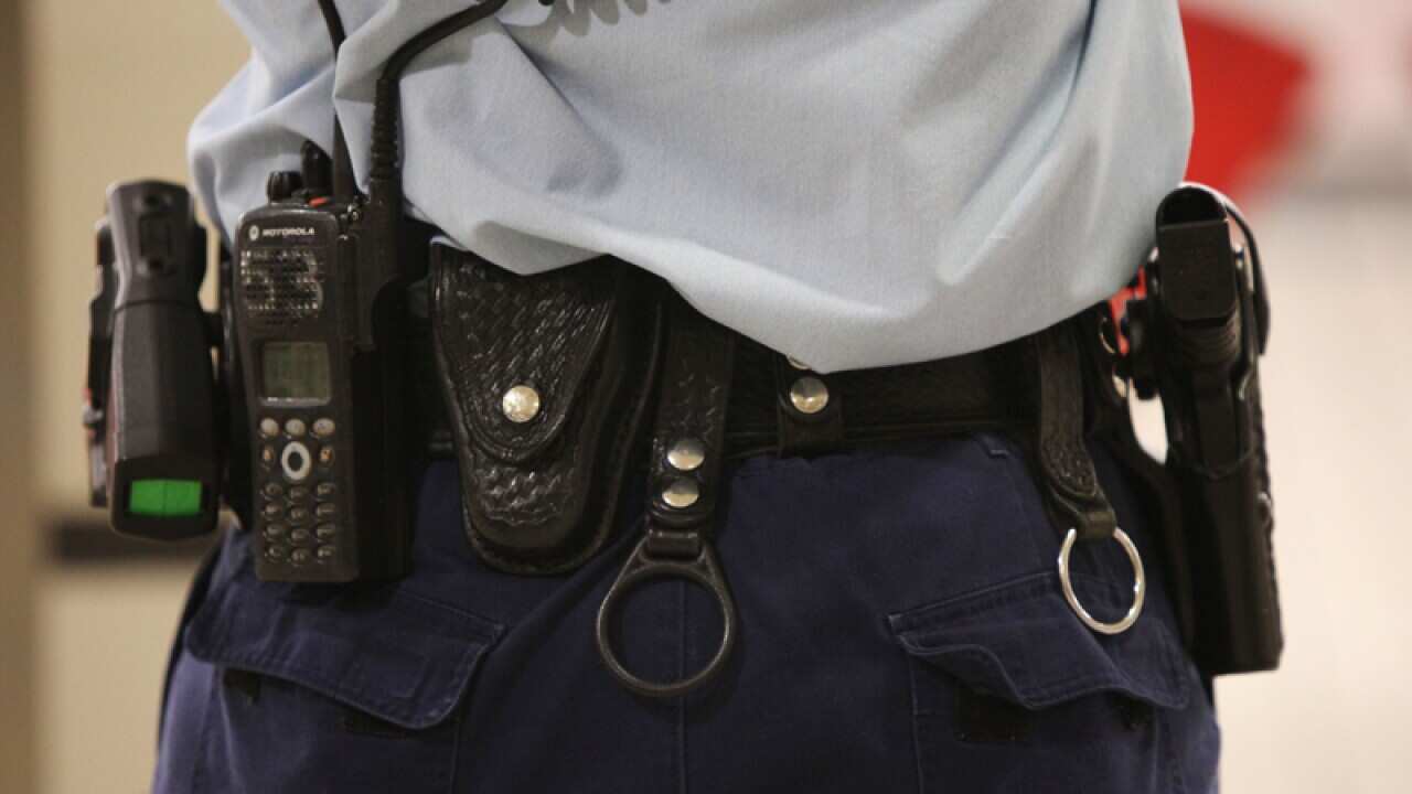 A police officer armed with a gun and a taser stun gun