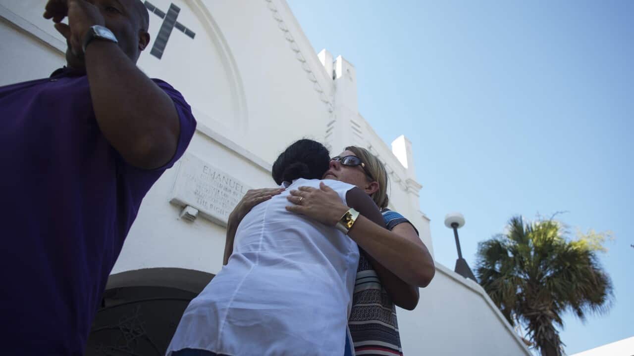 People are seen here hugging at the memorial site of the Emanuel African Methodist Episcopal (AME) Church where nine people were murdered in Charleston, South Carolina, USA, 18 June 2015. (EPA/JOHN TAGGART)
