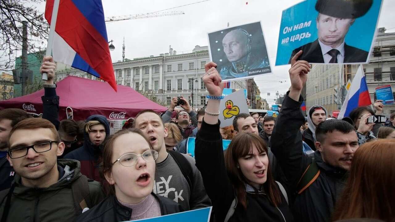 Demonstrators carry posters depicting Russian President Vladimir Putin during a massive protest rally in St Petersburg, Russia.