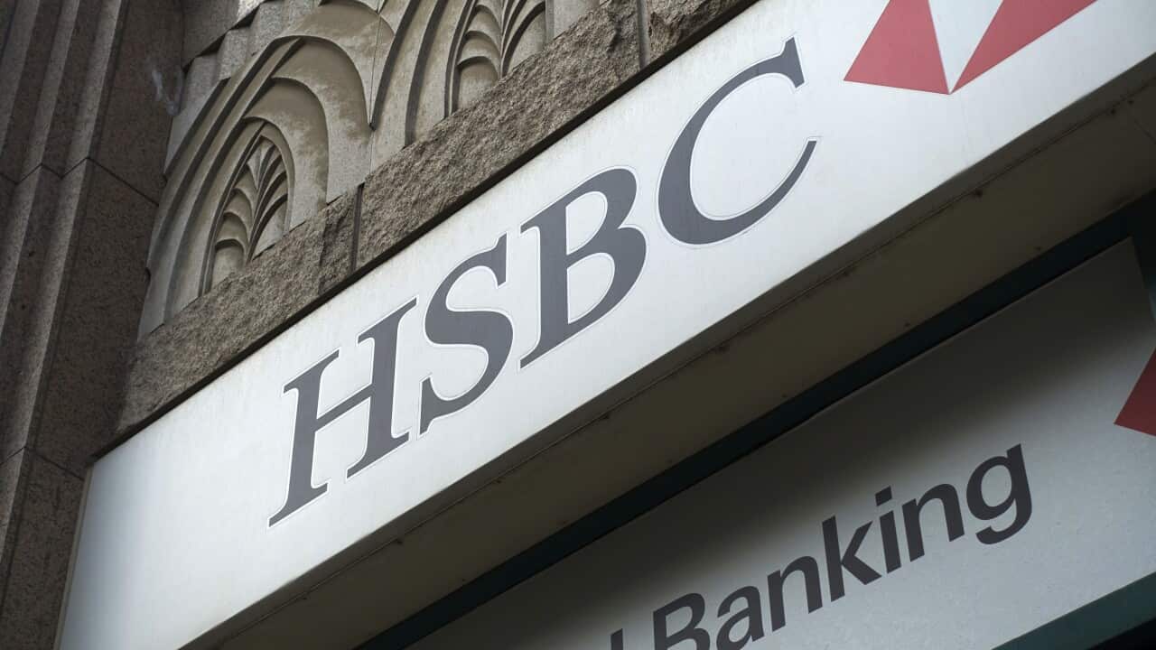 A large sign on a building reading 'HSBC' with a red symbol next to it