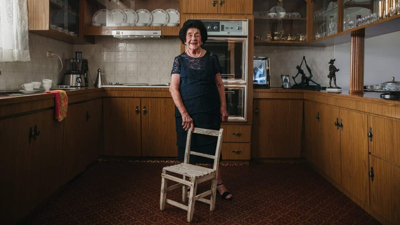 Nina Miragliotta stands in her kitchen proudly laying a hand on the chair her father made her 96 years ago