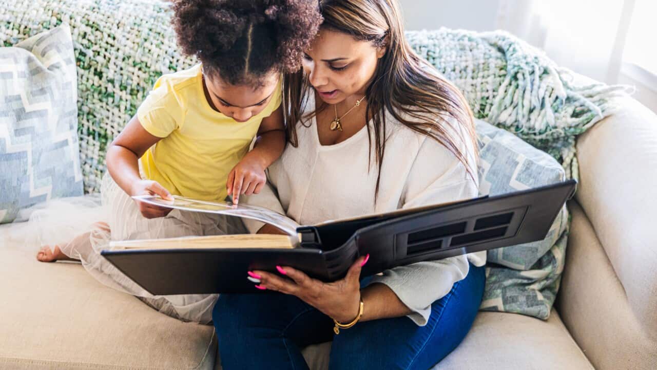 Mother and daughter looking at photo album