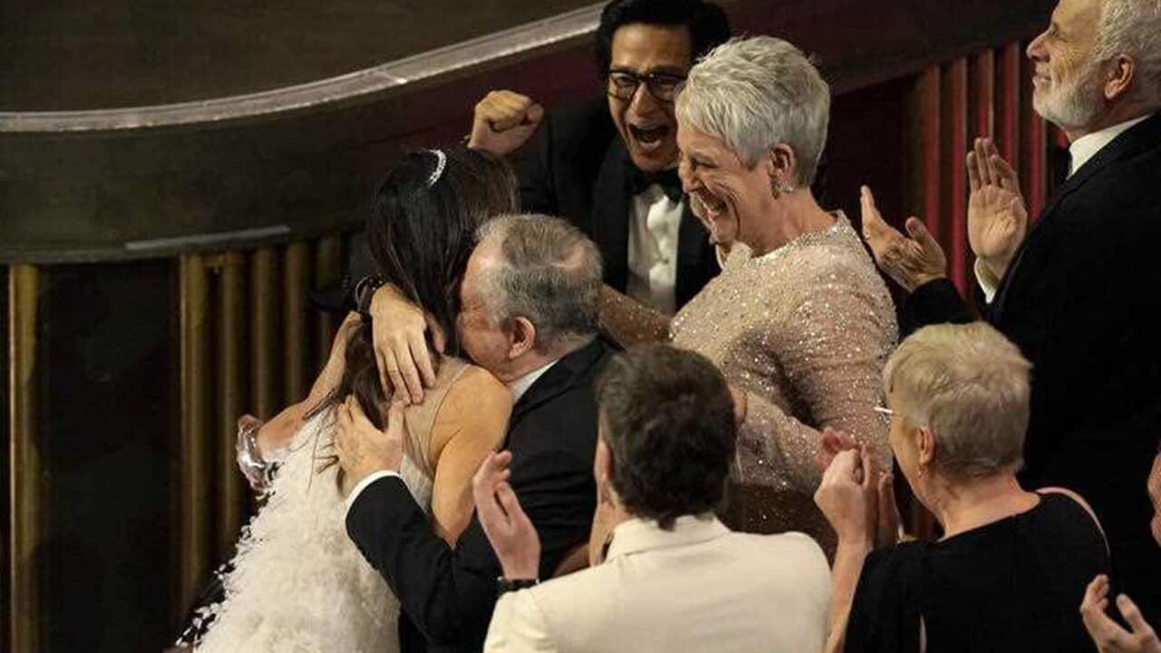 Michelle Yeoh is embraced as she accepts her award (AAP).jpg