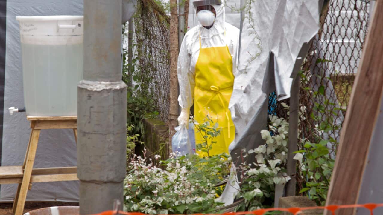 a healthcare worker walking near a Ebola isolation unit