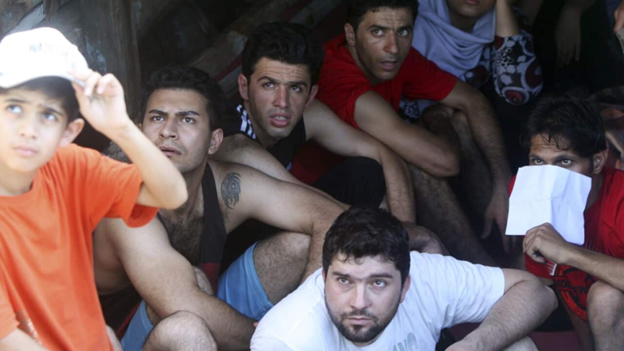 Iranian asylum seekers listen to an official on a boat
