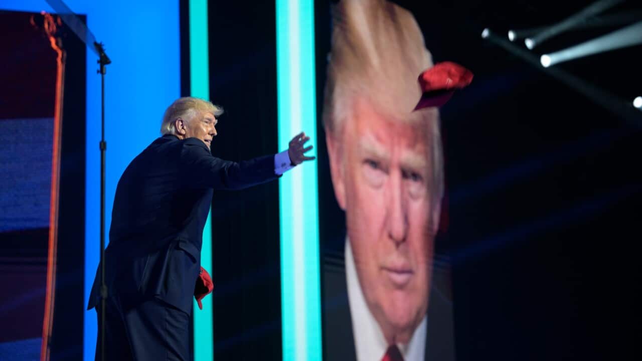 Former President Donald Trump tosses hats into the crowd before addressing attendees during the Turning Point USA Student Action Summit, Saturday, July 23, 2022, in Tampa, Florida.