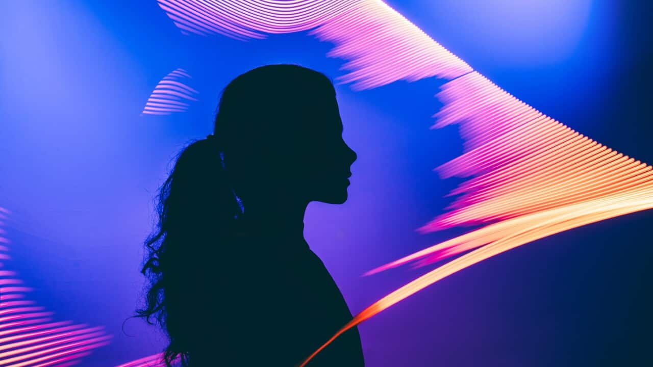 A metaphoric portrait of a human interacting with an AI, illuminated by the facial authentication glow to explore the virtual Universe
