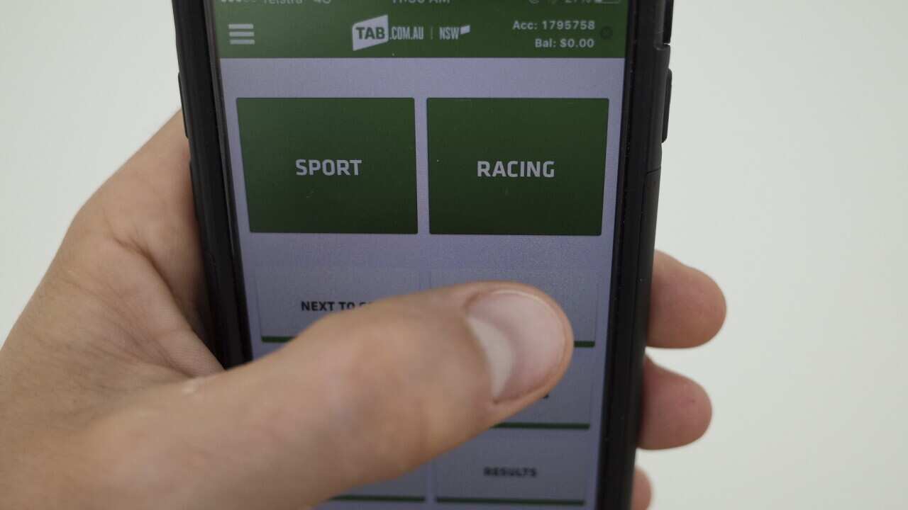 The TAB online betting app is seen on an iPhone in Canberra, Monday, Nov. 2, 2015. (AAP Image/Lukas Coch) NO ARCHIVING