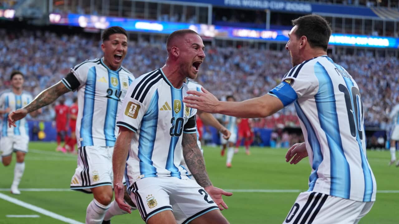 Three Argentinian footballers celebrate a goal at the World Cup in 2026.