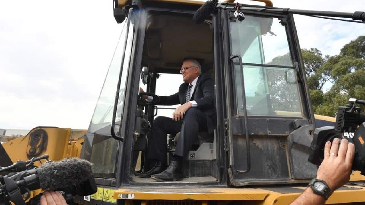 Prime Minister Scott Morrison in the cabin of a loader