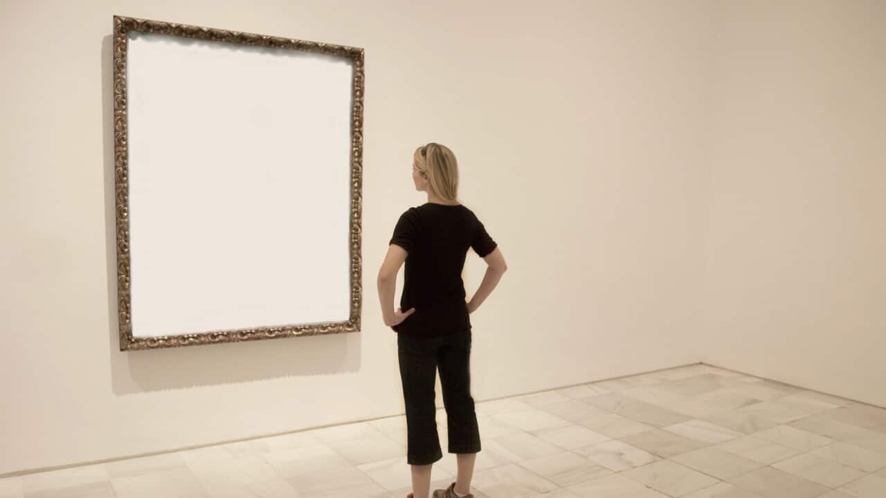 Young lady looking at blank art frame.