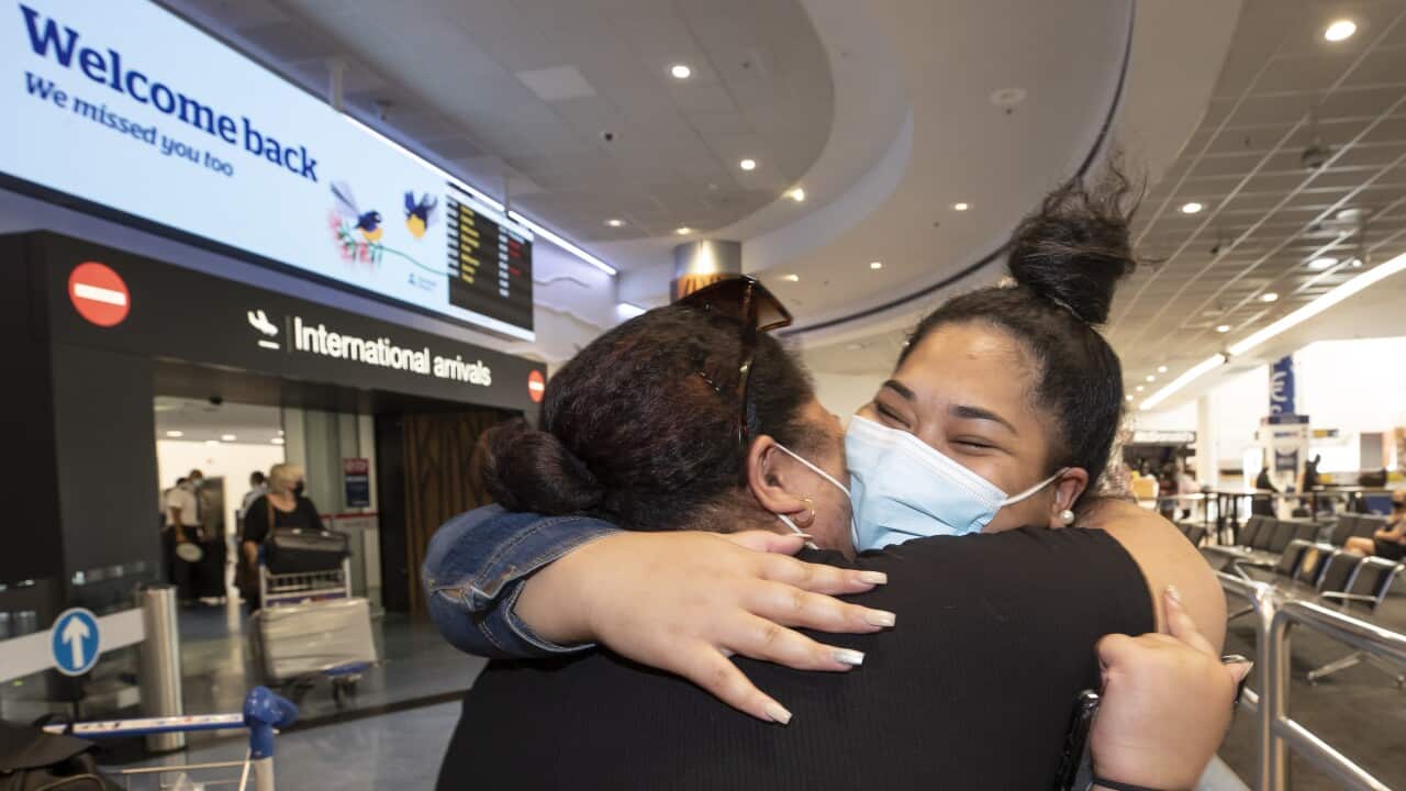 Wanawake wawili wakumbatiana katika uwanja wakimataifa wa Auckland, New Zealand, baada ya mmoja wao kuwasili kwa ndege kutoka Australia.